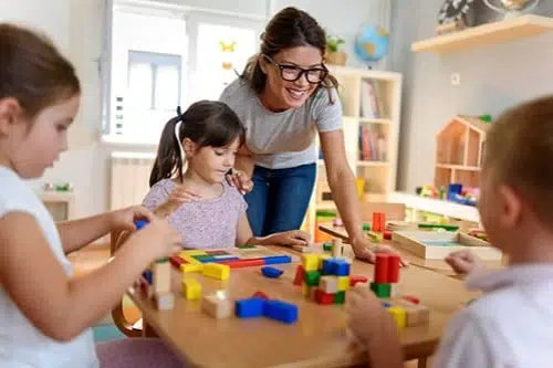 3 preschoolers with educator at early learning centre