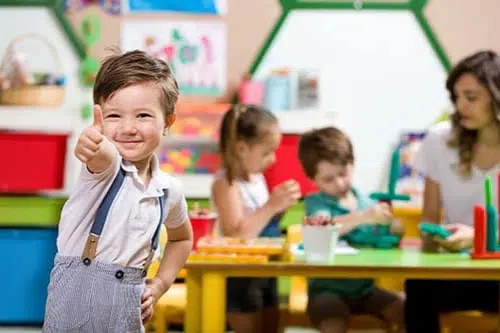 Preschooler giving thumbs up during art class at early learning centre